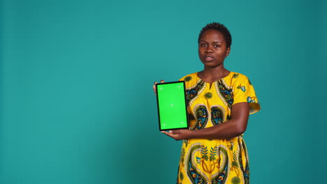 Feminine-person-in-native-clothing-holds-a-tablet-with-mockup-screen