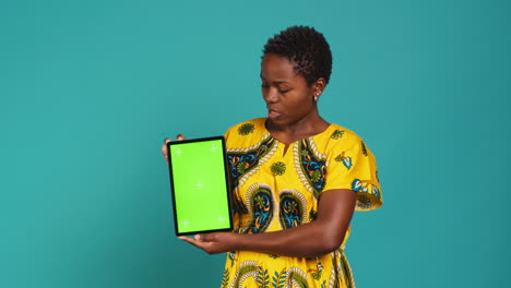 Feminine-person-in-native-clothing-holds-a-tablet-with-mockup-screen