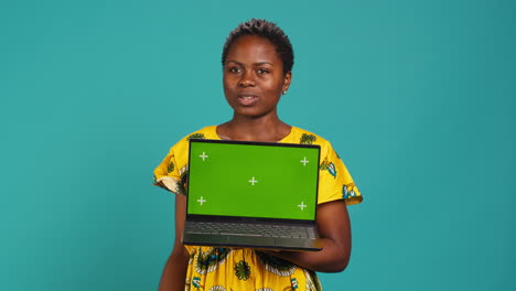 Natural-smiling-woman-posing-with-a-green-screen-on-laptop