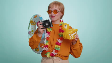 Happy-young-woman-tourist-photographer-taking-photos-on-retro-camera-and-smiling,-holiday-vacation