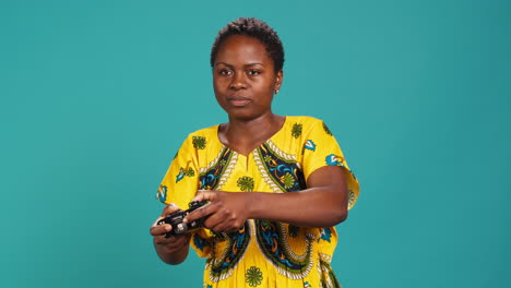 Optimistic-confident-woman-playing-videogames-on-console-in-studio