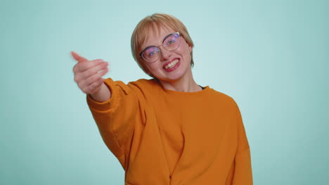 Young-happy-blonde-woman-in-glasses-spread-hands-and-give-hug-embrace-to-you-on-blue-background