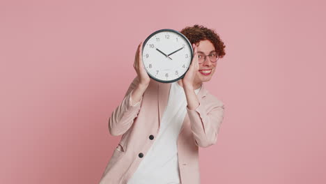 Happy-smiling-stylish-man-holding-office-clock-hiding-behind-checking-time-on-watch-obscuring-face