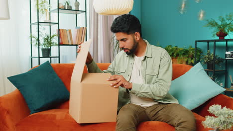 Angry-dissatisfied-shopper-Indian-man-unpacking-parcel-feeling-upset,-confused,-wrong-delivery