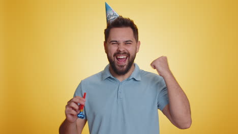 Happy-excited-lucky-man-wearing-birthday-hat-cone-blow-pipe-celebrating-party-success-win-victory