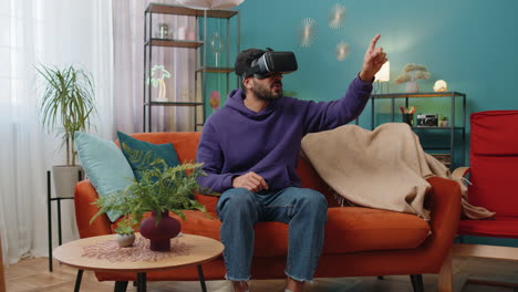 Man-using-virtual-reality-futuristic-technology-headset-to-play-simulation-3D-video-game-at-home