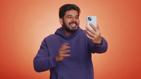 Indian-young-man-traveler-blogger-taking-selfie-on-smartphone-communicating-video-call-online-stream