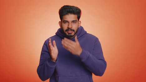 Young-indian-man-presses-finger-to-lips-makes-silence-gesture-sign-do-not-tells-secret,-stop-gossip