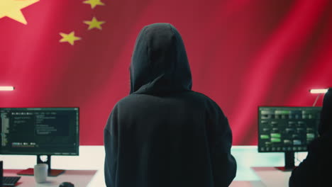 Hacker-Gubernamental-En-Oficina-De-Alta-Tecnología-Con-Bandera-China-Mostrada-En-Pantalla-Grande