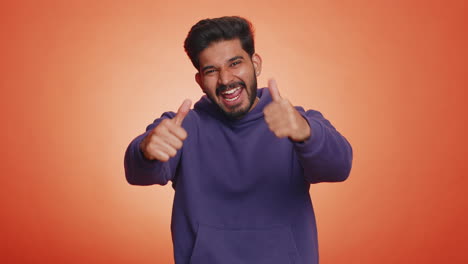 Indian-young-man-raises-thumbs-up-agrees-or-gives-positive-reply-recommends-advertisement-likes-good