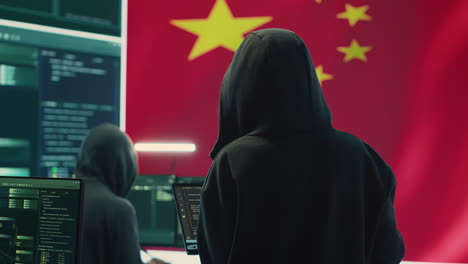 Chinese-hacker-working-in-governmental-hacking-room-with-Chinese-flag