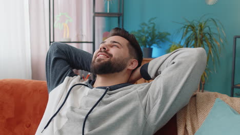 Joven-Cansado-Tumbado-En-Un-Cómodo-Sofá,-Descansando,-Siesta-Diurna-Relajándose-Y-Durmiendo