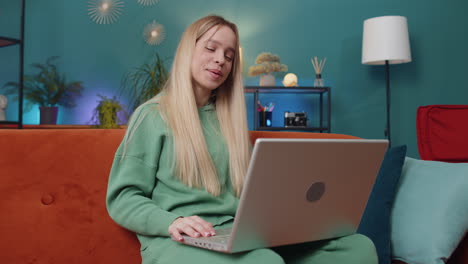 Woman-sitting-on-home-couch,-looking-at-camera,-making-video-conference-call-with-friends-or-family