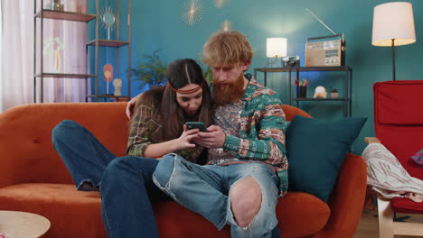 Family-married-hippie-couple-use-mobile-smartphone-found-great-big-win-good-news-celebrate-victory