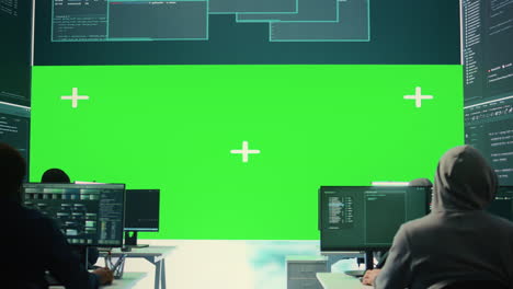 Team-of-governmental-hackers-look-at-green-screen-in-high-tech-agency-office