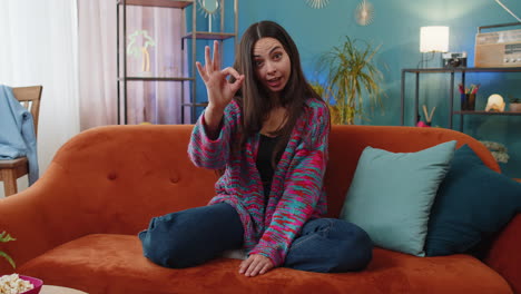 Happy-cheerful-young-woman-looking-approvingly-at-camera-showing-ok-gesture,-positive-like-sign