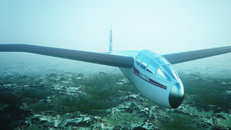 An-aerial-view-of-the-white-sailplane-with-no-propeller-calmly-gliding-in-the-sky,-over-snow-covered-mountains.-Flying-aerodynamic-aircraft-is-a-great-way-of-spend-leisure-time.