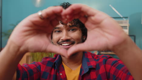 Happy-indian-man-guy-makes-symbol-of-love-showing-heart-sign-to-camera-express-romantic-feelings