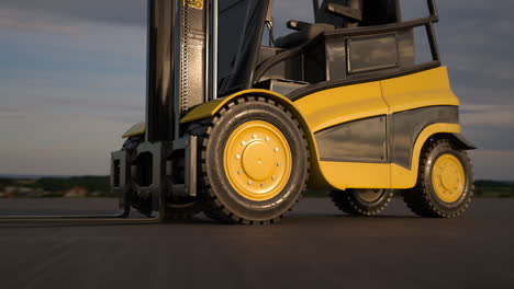 Modern-yellow-forklift-truck.-Professional-transportation-machine-is-using-hydraulic-machinery-to-load-heavy-cargo.-Tractor-moving-boxes-in-a-warehouse.-Industrial-and-logistic-concept.