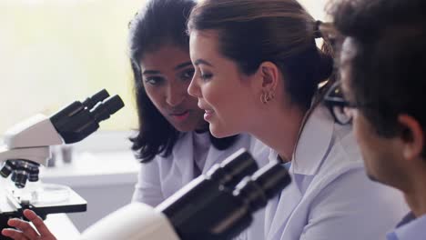 Scientists-with-Microscopes-Working-in-Laboratory.science-research,-work-and-people-concept-international-female-scientists-with-microscopes-working-in-laboratory