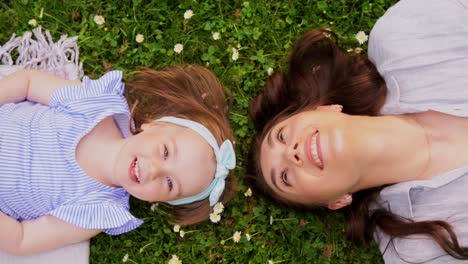 Madre-Feliz-Con-Una-Niña-Tumbada-En-El-Césped-En-El-Parque.-Concepto-De-Familia,-Maternidad-Y-Personas-Madre-Feliz-Y-Sonriente-Con-Una-Niña-Tumbada-En-El-Césped-En-El-Parque