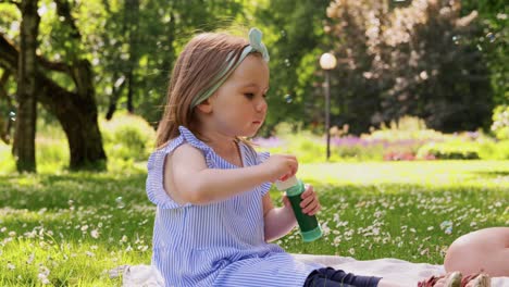 Madre-Con-Hija-Soplando-Pompas-De-Jabón-En-El-Parque.concepto-De-Familia,-Maternidad-Y-Personas-Madre-Feliz-Con-Hija-Pequeña-Soplando-Pompas-De-Jabón-En-El-Parque-O-Jardín-De-Verano