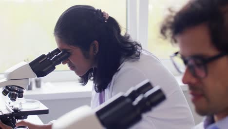 Scientists-with-Microscopes-Working-in-Laboratory.science-research,-work-and-people-concept-international-female-scientists-with-microscopes-working-in-laboratory