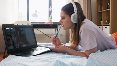 Estudiante-Con-Computadora-Portátil-Aprendiendo-En-Línea-En-Casa.-Escuela,-Educación-En-Línea-Y-Concepto-De-Aprendizaje-Electrónico-Adolescente-Estudiante-Con-Computadora-Portátil-Teniendo-Clase-De-Química-Y-Escribiendo-En-Un-Cuaderno-Acostado-En-La-Cama-En-Casa