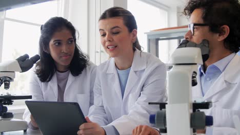 Scientists-with-Microscopes-Working-in-Laboratory.science-research,-work-and-people-concept-international-female-scientists-with-microscopes-working-in-laboratory