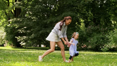 Madre-Feliz-Con-Una-Hija-Pequeña-Jugando-En-El-Parque.-Concepto-De-Familia,-Maternidad-Y-Personas-Madre-Feliz-Con-Una-Hija-Pequeña-Jugando-En-El-Parque-O-Jardín-De-Verano