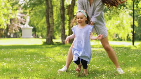 Madre-Feliz-Con-Una-Hija-Pequeña-Jugando-En-El-Parque.-Concepto-De-Familia,-Maternidad-Y-Personas-Madre-Feliz-Con-Una-Hija-Pequeña-Jugando-En-El-Parque-O-Jardín-De-Verano