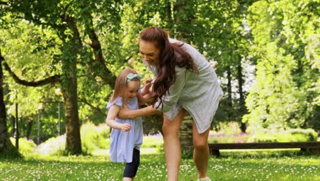 Madre-Feliz-Con-Una-Hija-Pequeña-Jugando-En-El-Parque.-Concepto-De-Familia,-Maternidad-Y-Personas-Madre-Feliz-Con-Una-Hija-Pequeña-Jugando-En-El-Parque-O-Jardín-De-Verano