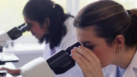 Scientists-with-Microscopes-Working-in-Laboratory.science-research,-work-and-people-concept-international-female-scientists-with-microscopes-working-in-laboratory