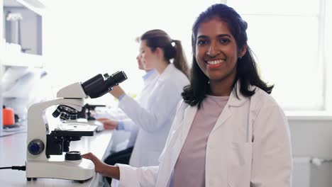 Scientists-with-Microscopes-Working-in-Laboratory.science-research,-work-and-people-concept-international-female-scientists-with-microscopes-working-in-laboratory