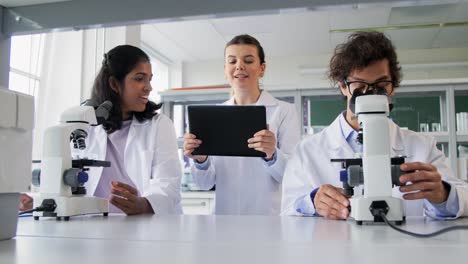 Scientists-with-Microscopes-Working-in-Laboratory.science-research,-work-and-people-concept-international-female-scientists-with-microscopes-working-in-laboratory