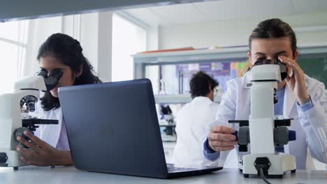 Scientists-with-Microscopes-Working-in-Laboratory.science-research,-work-and-people-concept-international-female-scientists-with-microscopes-working-in-laboratory