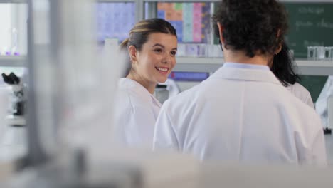 International-Group-of-Scientists-in-Laboratory.science-research,-work-and-people-concept-international-group-of-happy-scientists-with-clipboards-discussing-report-in-laboratory