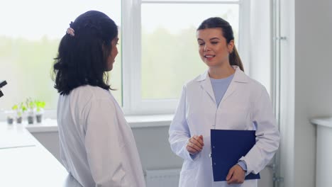 Scientists-Shaking-Hands-in-Laboratory.science,-work-and-people-concept-international-group-of-happy-scientists-shaking-hands-in-laboratory