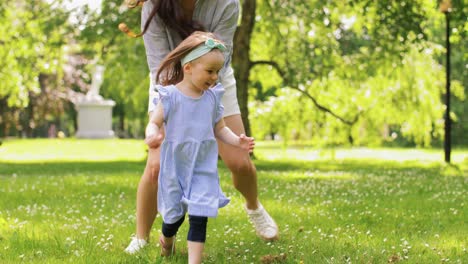 Madre-Feliz-Con-Una-Hija-Pequeña-Jugando-En-El-Parque.-Concepto-De-Familia,-Maternidad-Y-Personas-Madre-Feliz-Con-Una-Hija-Pequeña-Jugando-En-El-Parque-O-Jardín-De-Verano