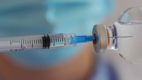 Close-Up-of-Syringe-Filling-with-Medicine.healthcare-and-vaccination-concept-close-up-of-syringe-filling-with-medicine-from-bottle