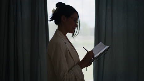 Silhouette-of-Happy-Pensive-Businesswoman-by-Window-in-Office