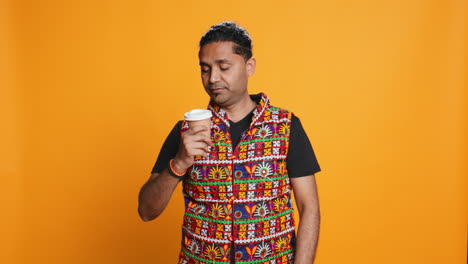 Tired-man-drinking-coffee,-isolated-over-studio-background