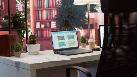 Empty-home-office-setup-showing-documents-and-financial-reports-on-laptop