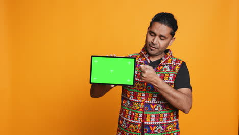 Portrait-of-man-doing-influencer-marketing-using-green-screen-tablet