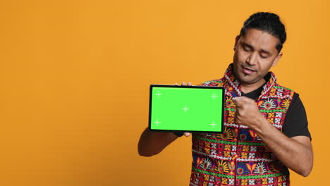 Portrait-of-man-doing-influencer-marketing-using-green-screen-tablet