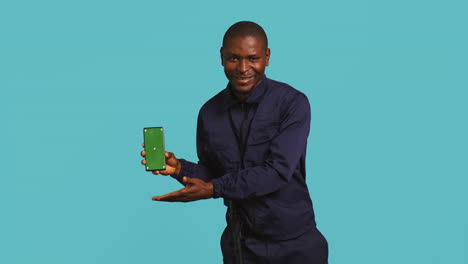 Portrait-of-upbeat-security-staff-member-showing-green-screen-smartphone