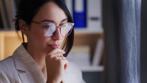 Pensive-Woman-Stands-by-Window-Looking-for-Inspiration