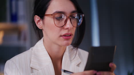 Worried-Businesswoman-Counts-Business-Expenses-on-Calculator