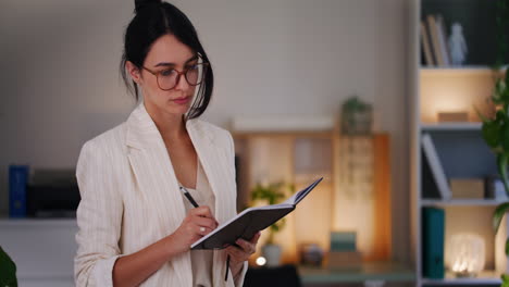 Una-Mujer-De-Negocios-Segura-Planea-Reuniones-En-Un-Cuaderno