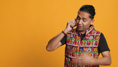 Irked-man-fighting-with-friends-during-telephone-call,-studio-background